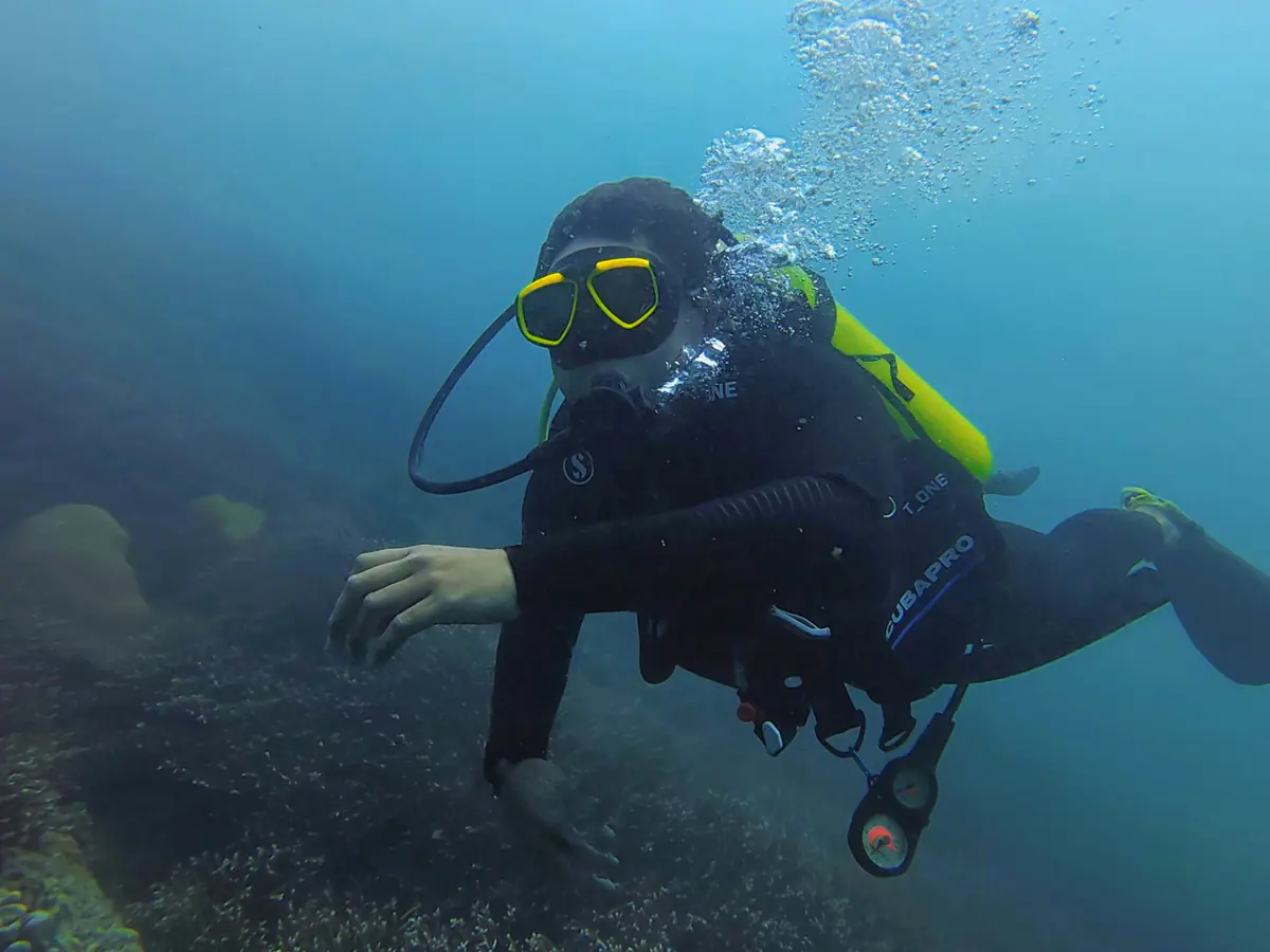 Satriko scuba diving over the coral at Lava Flow